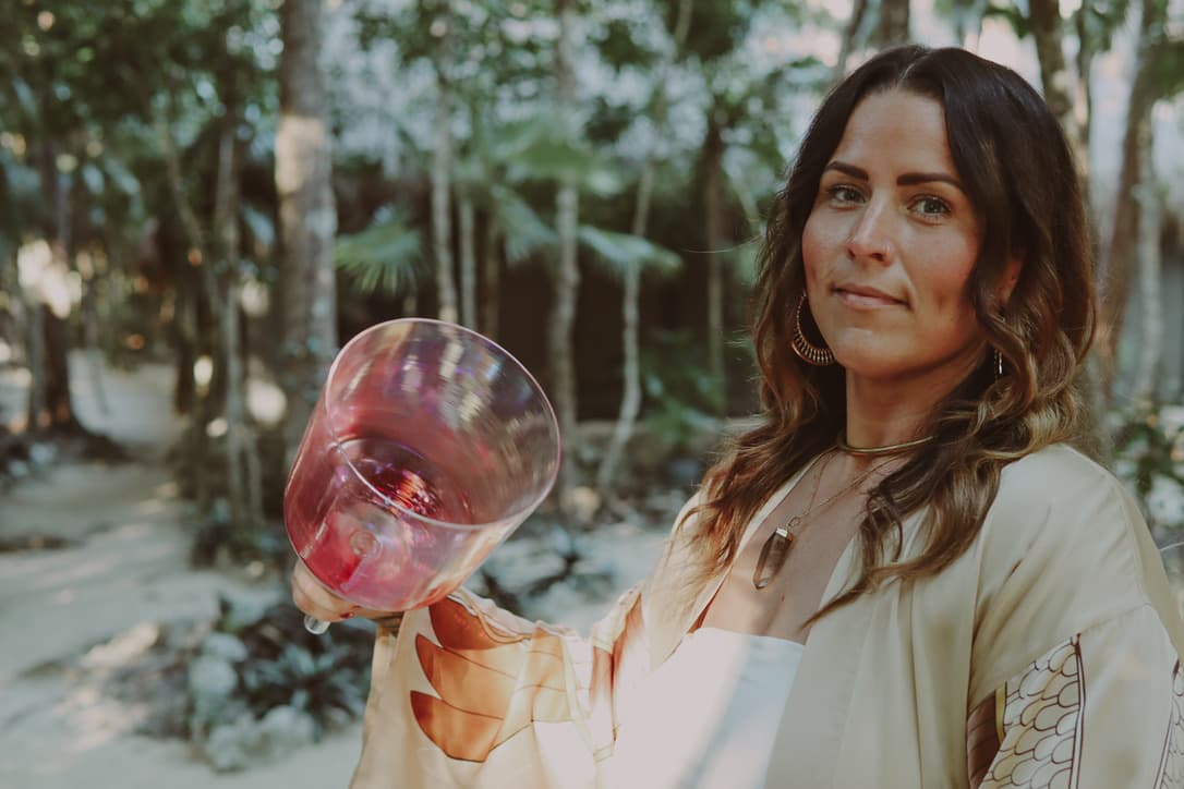 Kate Gajewski holding a rose-colored sound healing bowl outdoors